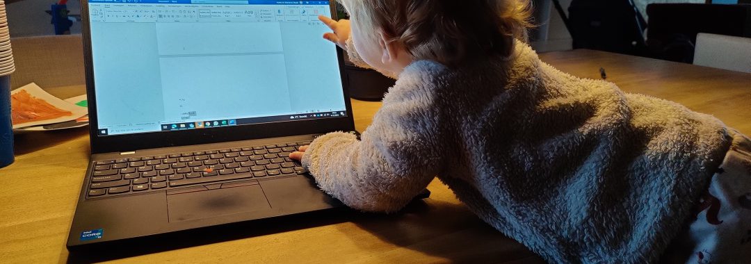 Kind van 1,5 jaar de laptop op tafel