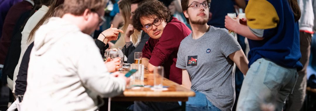 Groep jongeren aan tafel met glazen tijdens een bijeenkomst