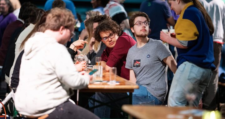 Groep jongeren aan tafel met glazen tijdens een bijeenkomst